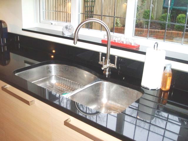 undermounted stainless steel double sink & black granite worktop & window sill
