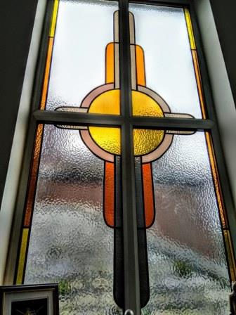 The original Art Deco stained glass bathroom window sits above the bath